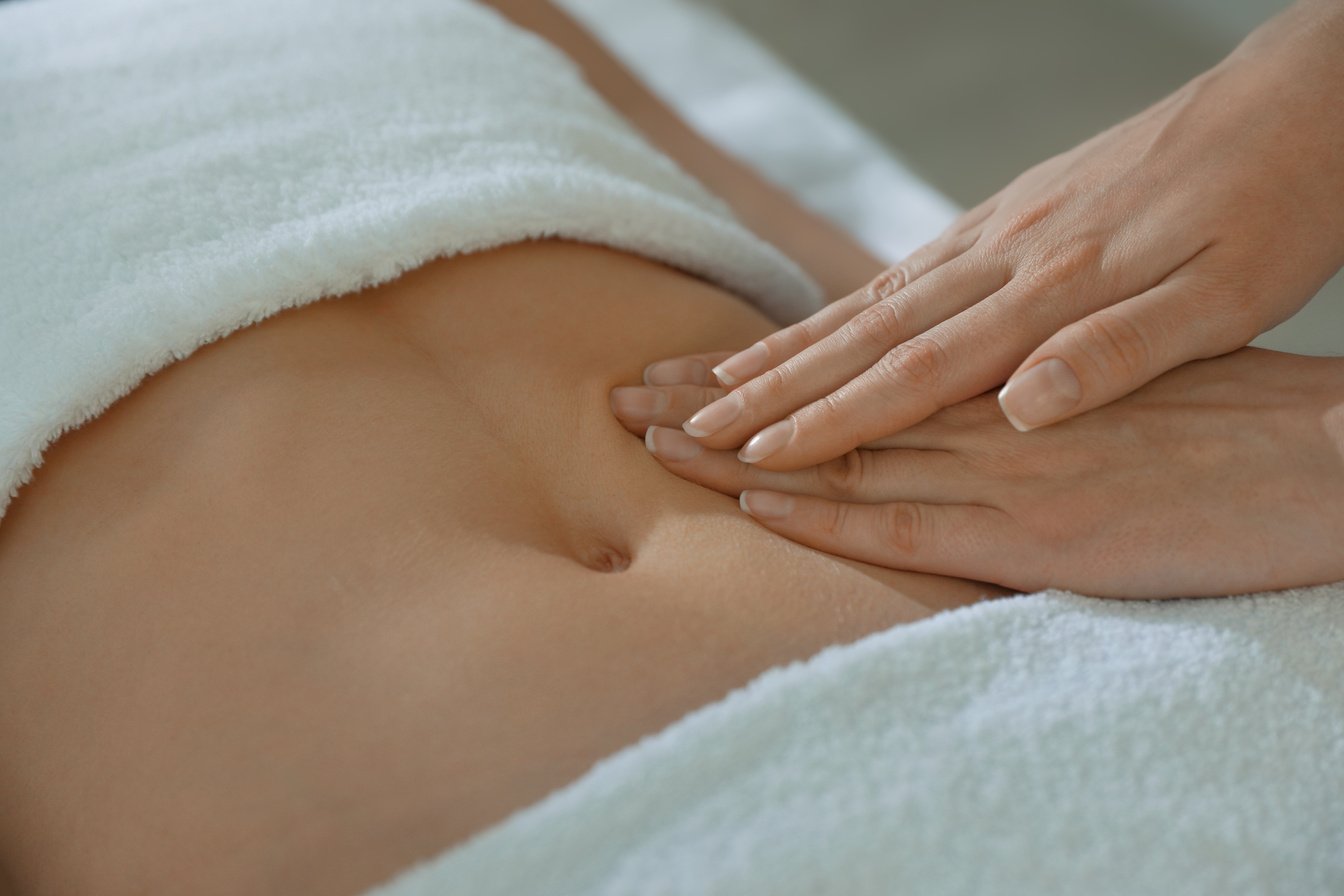 Hands Pressing on a Woman's Stomach 