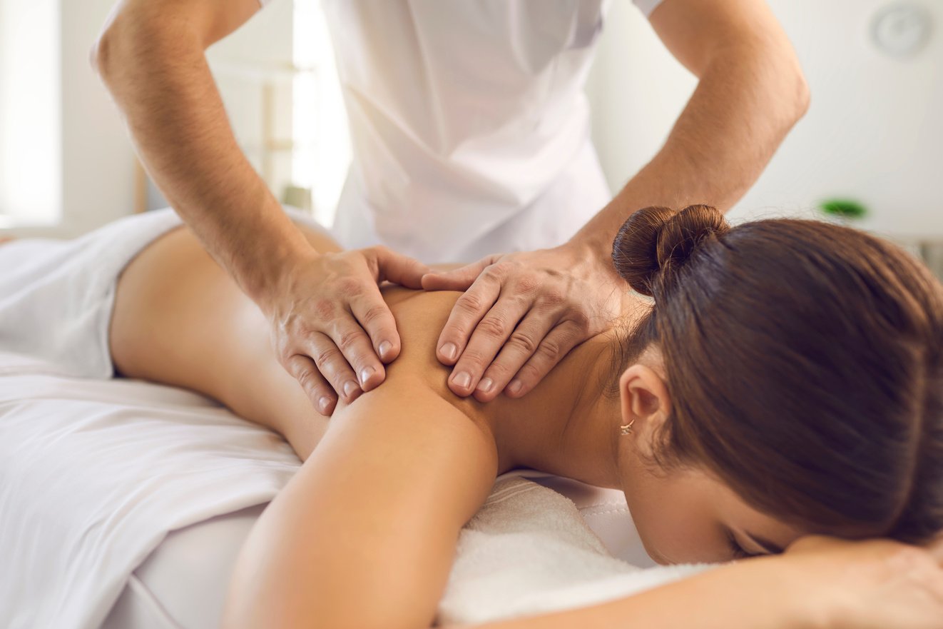 Hands of Professional Chiropractor or Masseur Making Massage of Back and Shoulders for Woman